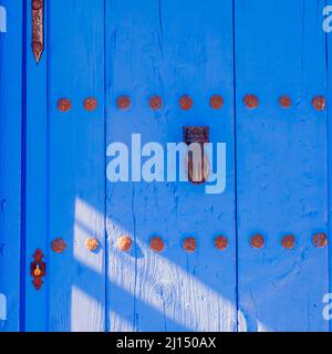 Golden Metal Türklopfer an einer alten blauen Holztür Stockfoto