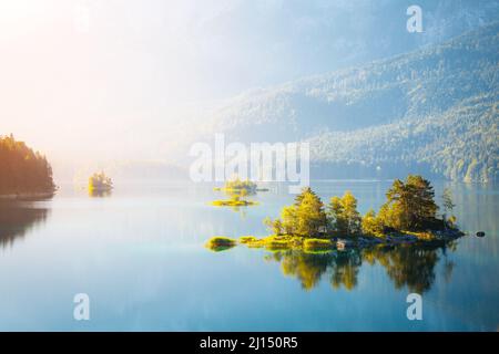 Blick auf die Inseln und türkisblaues Wasser am Eibsee am Fuße des Mt. Zugspitze. Morgen Szene. Lage berühmten Resort Garmisch-Partenkirchen, Bav Stockfoto