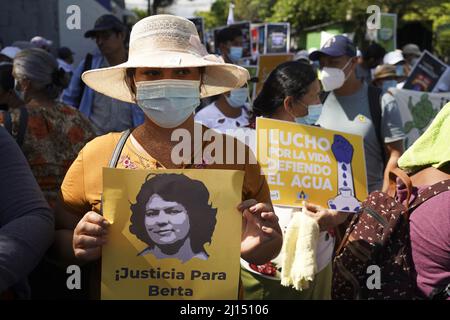 San Salvador, El Salvador. 22. März 2022. Eine Frau hält ein Bild der ermordeten Umweltaktivistin Berta Caceres während einer Kundgebung zum Weltwassertag. Caceres war 2016 in Honduras ermordet worden. Sie setzte sich in Honduras für die Rechte der indigenen Bevölkerung von Lenca und gegen den Bau des Wasserkraftwerks Agua Zarca durch die Firma Desa ein. Quelle: Camilo Freedman/dpa/Alamy Live News Stockfoto