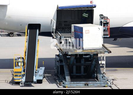 Ladegeräte werden am internationalen Flughafen in das Flugzeug geladen Stockfoto