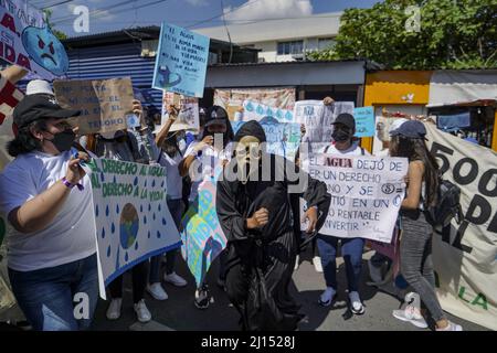 San Salvador, El Salvador. 22. März 2022. Ein als Tod gekleideter Protestler tanzt während einer Kundgebung am Weltwassertag. „Das Recht auf Wasser ist das Recht auf Leben“, heißt es auf dem Plakat eines Demonstrators. Quelle: Camilo Freedman/dpa/Alamy Live News Stockfoto