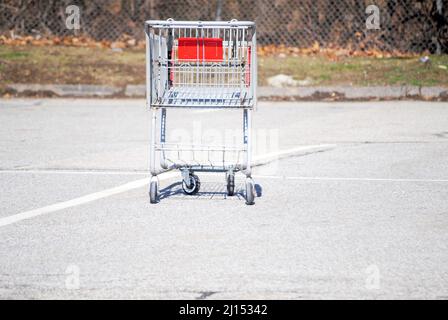 Ein alter rostiger verlassene Metalleinkaufswagen wurde draußen auf dem Parkplatz gelassen Stockfoto