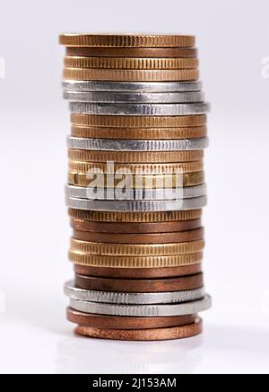 Jeder kleine Teil hilft. Studioaufnahme eines Münzstapels auf weißem Hintergrund. Stockfoto