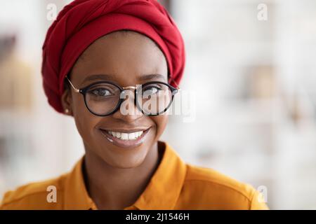 Nahaufnahme Porträt einer hübschen jungen schwarzen Dame mit rotem Kopftuch Stockfoto