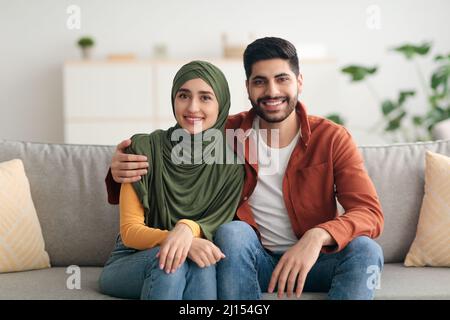 Nahöstliches Paar Mit Ehefrau, Die Hijab Umarmt, Zu Hause Stockfoto