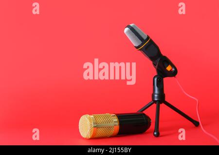 Moderne Mikrofone auf rotem Hintergrund Stockfoto