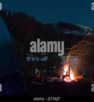 Feuer brennt auf dem Campingplatz in der Tiefe der Nacht Stockfoto