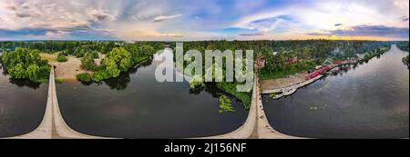 Brücke über den Fluss in den Wald. Panoramaaufnahme von einem Quadcopter. Stockfoto