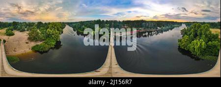 Brücke über den Fluss in den Wald. Panoramaaufnahme von einem Quadcopter. Stockfoto