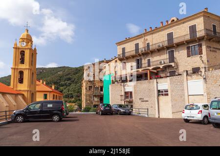 Olmeto, Frankreich - August 25,2018: Straßenansicht mit Autos, die in der Nähe der Kirche Santa Maria Assunta von Olmeto, Departement Corse-du-Sud von Frankreich auf der i geparkt sind Stockfoto