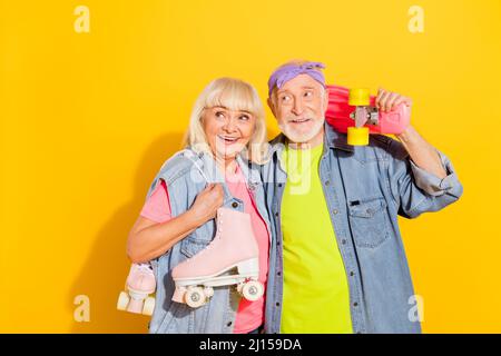 Foto von ziemlich nachdenklich Mann Frau tragen Jeans Hemden halten Rollen lange Brett leeren Raum isoliert gelbe Farbe Hintergrund Stockfoto
