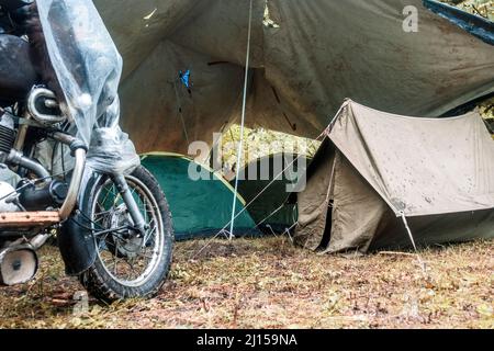 Motorrad in der Nähe von Zelten im Wald. Motorradreise Stockfoto