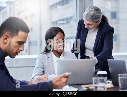 Versuchen wir, dies auf eine neue Art und Weise zu tun. Aufnahme von zwei Geschäftsfrauen, die in einem Büro an einem Laptop arbeiten. Stockfoto