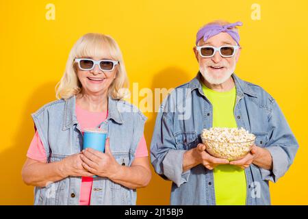 Foto von lustigen niedlichen Mann Frau tragen Jeans Hemden beobachten Film essen Popcorn isoliert gelbe Farbe Hintergrund Stockfoto