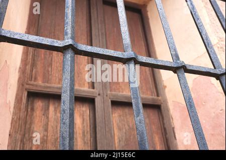 Detail eines alten geschmiedeten Zauns auf einem antiken Fenster Stockfoto