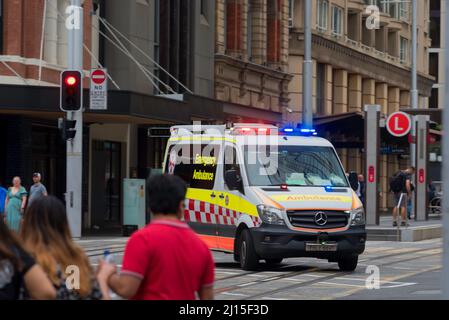 Ein Krankenwagen mit blinkenden Lichtern wechselt an einem Samstag von der Hunter Street in die George Street im Zentrum von Sydney, Australien Stockfoto