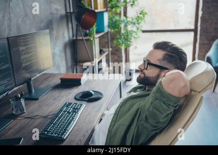 Profil Seitenansicht Porträt von attraktiven qualifizierten verträumten Brunet Kerl Entwicklung Website-Projekt Start-up am Arbeitsplatz Arbeitsplatz Workstation drinnen Stockfoto