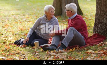 Ältere kaukasische verheiratete Menschen sprechen im Park mit Picknick voller Schuss selektiver Fokus . Hochwertige Fotos Stockfoto