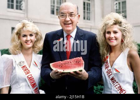 North Carolina Jesse Helms hält Wassermelone und steht zwischen zwei Schönheitswettbewerbern bei einer Veranstaltung, die von der National Watermelon Association, Washington DC, USA, gesponsert wird, Laura Patterson, Roll Call Photograph Collection, Juli 1991 Stockfoto