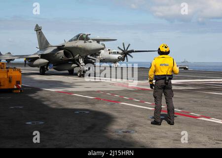 220317-N-UN585-1384 MITTELMEER (17. März 2022) Ein französischer Dassault Rafale, links, Und E-2C Hawkeye-Flugzeuge, bereiten sich auf den Start vom Flugdeck des französischen Flugzeugträgers Charles de Gaulle (R 91) vor, als der Arleigh Burke-Klasse-Lenkraketen-Zerstörer USS Ross (DDG 71) in der Nähe im Mittelmeer patrouilliert, März 17. Ross, der im spanischen Rota stationiert ist, ist auf seiner Patrouille 12. im Einsatzgebiet der Sechsten Flotte der USA, um regionale Verbündete und Partner sowie nationale Sicherheitsinteressen der USA in Europa und Afrika zu unterstützen. (USA Navy Foto von Mass Communication Specialist 2. Class CL Stockfoto