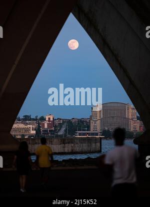 Über dem National Harbor in Fort Washington, Maryland, steigt ein fast Vollmond, Dienstag, 25. Mai 2021, Aus der Sicht von Alexandria, Virginia. Bildnachweis: (NASA/Bill Ingalls) Stockfoto