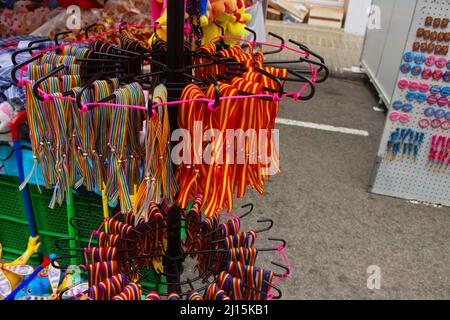 Nahaufnahme einiger mehrfarbiger Armbänder, die von Hand hergestellt werden und an einem Straßenmarktstand verkauft werden Stockfoto