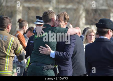 London, Großbritannien. 22. März 2022. Tobias Ellwood - der Abgeordnete, der versucht hat, den sterbenden Terrorhelden PC Keith Palmer zu retten, wird gesehen, wie er einen Sanitäter vom Londoner Krankenwagen umarmt, der 2017 an der Westminster Bridge zum ersten Mal am Schauplatz des Terroranschlags war. Quelle: @Dmoonuk/Alamy Live News Stockfoto