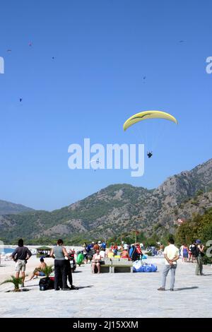 FETHIYE, TÜRKEI - 22. OKTOBER: Paraglider-Landung am Fethiye Beach, 22. Oktober 2003 in Fethiye, Türkei. Jedes Jahr besuchen viele Gleitschirmflieger das Fethiye Air Festival. Stockfoto