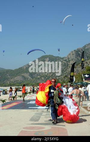 FETHIYE, TÜRKEI - 22. OKTOBER: Gleitschirm zum Fallschirm am Fethiye Beach, 22. Oktober 2003 in Fethiye, Türkei. Jedes Jahr besuchen viele Luftsportler das Fethiye Air Festival. Stockfoto