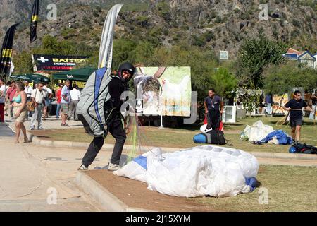 FETHIYE, TÜRKEI - 22. OKTOBER: Gleitschirmflieger sammeln am Fethiye Beach, 22. Oktober 2003 in Fethiye, Türkei. Jedes Jahr besuchen viele Luftsportler das Fethiye Air Festival. Stockfoto