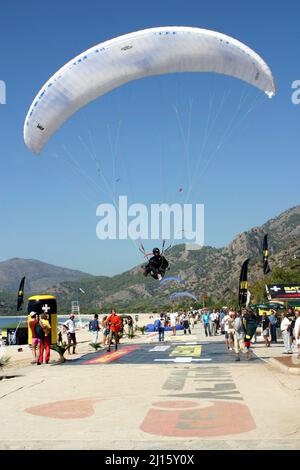 FETHIYE, TÜRKEI - 22. OKTOBER: Paraglider-Landung am Fethiye Beach, 22. Oktober 2003 in Fethiye, Türkei. Jedes Jahr besuchen viele Gleitschirmflieger das Fethiye Air Festival. Stockfoto