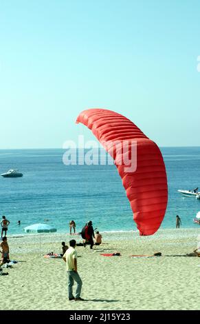 FETHIYE, TÜRKEI - 22. OKTOBER: Paraglider-Landung am Fethiye Beach, 22. Oktober 2003 in Fethiye, Türkei. Jedes Jahr besuchen viele Gleitschirmflieger das Fethiye Air Festival. Stockfoto