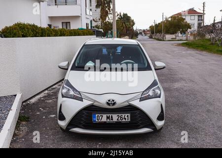 Side; Türkei – 28 2022. Februar: Der weiße Toyota Yaris wird an einem warmen Tag vor dem Hintergrund eines Baues, Bäumen, auf der Straße geparkt Stockfoto