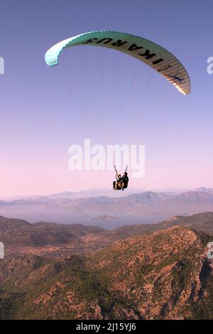 FETHIYE, TÜRKEI - 22. OKTOBER: Gleitschirmflug vom Berg Babadag, 22. Oktober 2003 in Fethiye, Türkei. Mount Babadag in der Nähe von Fethiye und ein berühmtes Gleitschirmgebiet in der Türkei. Stockfoto