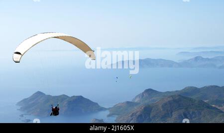 Gleitschirmfliegen vom Berg Babadag in Fethiye, Türkei. Mount Babadag in der Nähe von Fethiye und ein berühmtes Gleitschirmgebiet in der Türkei. Stockfoto