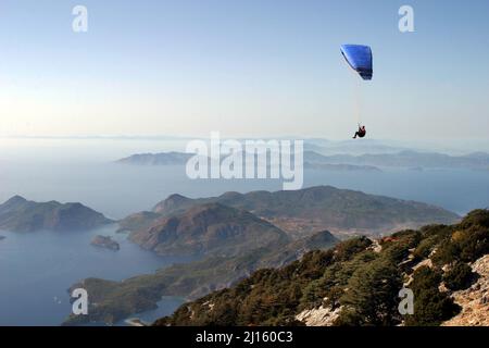 Gleitschirmfliegen vom Berg Babadag in Fethiye, Türkei. Mount Babadag in der Nähe von Fethiye und ein berühmtes Gleitschirmgebiet in der Türkei. Stockfoto