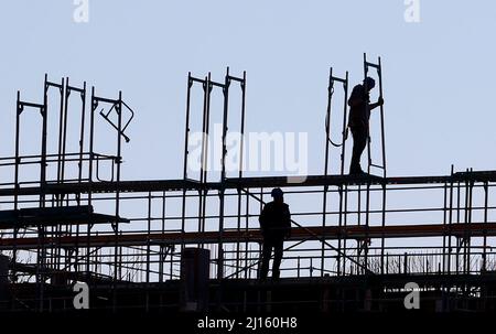 Landsberg Am Lech, Deutschland. 22. März 2022. Handwerker arbeiten am Gerüst beim Bau eines neuen Mehrfamilienhauses. Das ifo Institut veröffentlicht am Mittwoch seine neue Konjunkturprognose. (To dpa 'ifo Institute veröffentlicht neue Konjunkturprognosen') Quelle: Karl-Josef Hildenbrand/dpa/Alamy Live News Stockfoto