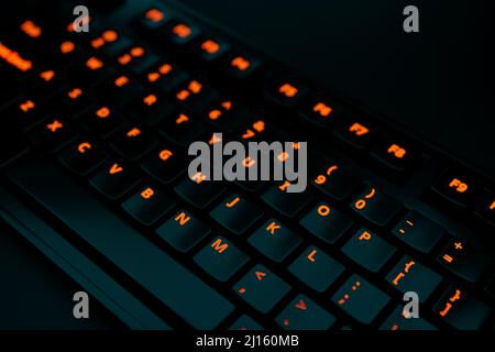 3D Abbildung, Nahaufnahme der realistischen Computer- oder Laptop-Tastatur mit orangefarbenen Neonlichtern auf schwarzem Hintergrund. Gaming-Tastatur mit LED-Hintergrundbeleuchtung Stockfoto