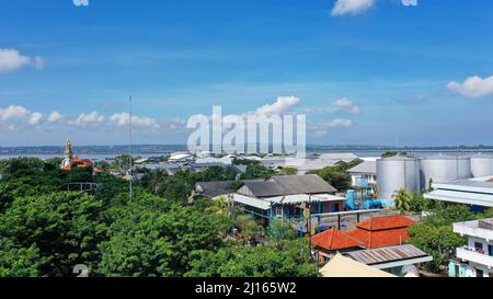 Hafen Benoa, Bali, Indonesien - Februar 26, 2019: Nahaufnahme von Pertmina Tankstelle auf Tanyung Benoa Halbinsel mit roten Dächern und baum laub Stockfoto