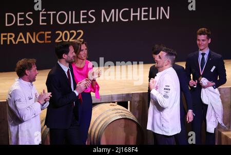 Cognac, Frankreich. 22. März 2022. Der französische Küchenchef Dimitri Droisneau (vorne R) zieht seine neue Chefjacke an, nachdem er bei der Verleihung des Michelin Guide Awards 2022 am 22. März 2022 in Cognac, Frankreich, einen dritten Michelin-Stern erhalten hat. Der Michelin Guide startete seine Ausgabe 2022 am Dienstag in Cognac, das erste Mal seit 122 Jahren, dass die Zeremonie außerhalb von Paris stattfand. Zwei Restaurants wurden mit der höchsten Auszeichnung von drei Sternen ausgezeichnet. Kredit: Gao Jing/Xinhua/Alamy Live Nachrichten Stockfoto