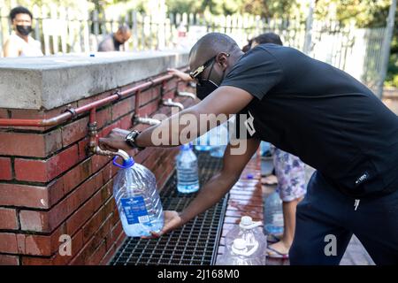 Kapstadt, Südafrika. 19. März 2022. Am 19. März 2022 füllt eine Person einen Eimer im Newlands Spring in Kapstadt, Südafrika. ZUM THEMA „Feature: Das Bewusstsein für den Wasserschutz liegt tief in Kapstadt“ Quelle: Lyu Tianran/Xinhua/Alamy Live News Stockfoto