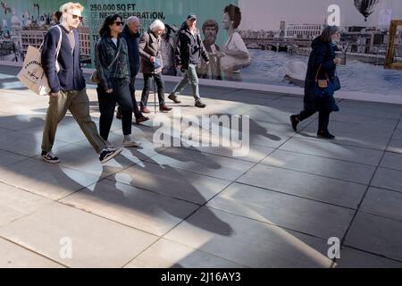 Fußgänger gehen am 17.. März 2022 in London, England, durch das reflektierte Licht auf dem Peter's Hill in der City of London, dem Finanzviertel der Hauptstadt. Stockfoto