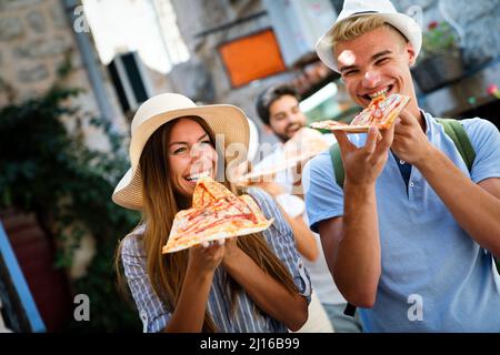 Freunde, die Spaß haben und Pizza essen. Dating, Konsumdenken, Essen und Lifestyle-Konzept. Stockfoto