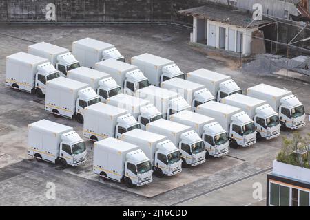 Einige Lkw stehen auf dem Parkplatz neben dem Logistiklager, viele Lkw stehen auf dem Logistiktransport-Parkplatz an. Stockfoto