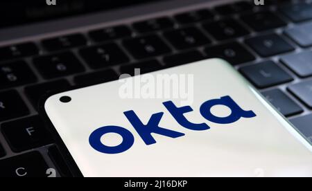 Okta Sicherheitsfirma Logo auf Smartphone und einem Laptop auf verschwommenem Hintergrund gesehen. Konzept für Hack. Stafford, Großbritannien, 22. März 2022. Stockfoto