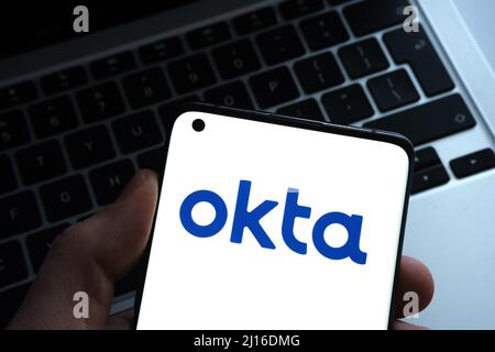 Okta Sicherheitsfirma Logo auf Smartphone und einem Laptop auf verschwommenem Hintergrund gesehen. Konzept für Hack. Stafford, Großbritannien, 22. März 2022. Stockfoto