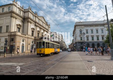 Stadt Mailand, Italien. Piazza della Scala mit dem Teatro alla Scala oder einfach La Scala im Zentrum von Mailand mit einer vorbeifahrenden gelben Straßenbahn Stockfoto