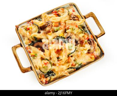 Draufsicht auf schmackhaft gebackenen Penne Gratin mit Champignons und Gemüse in Auflauf auf weißem isolierten Hintergrund serviert Stockfoto