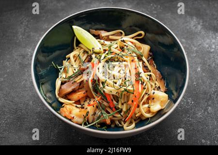 Spaghetti mit Meeresfrüchten auf dunklem Hintergrund. Garnelen, Tintenfisch Stockfoto