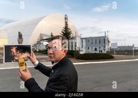 Ein Führer zeigt ein Foto von Elefantenfüßen im Reaktor 4, der während der Atomkatastrophe in Tschernobyl explodierte. Tschernobyl-Sperrzone. Stockfoto